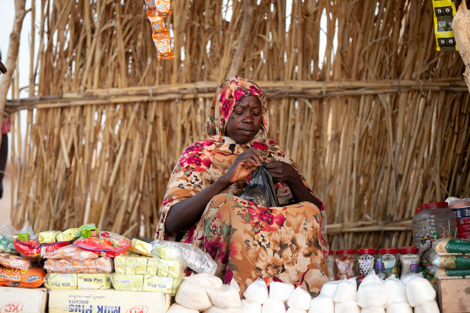Rayga at her market stall in Tawila, stocked with sugar, biscuits and staples.